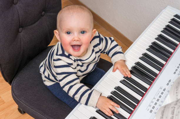 istock Cute baby trying to play on piano 675821820