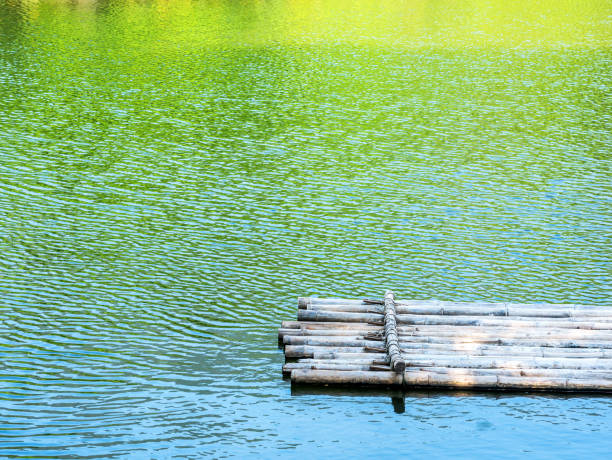 istock Bamboo raft in river with color reflection of tree,mountain and blue sky in river 675822458
