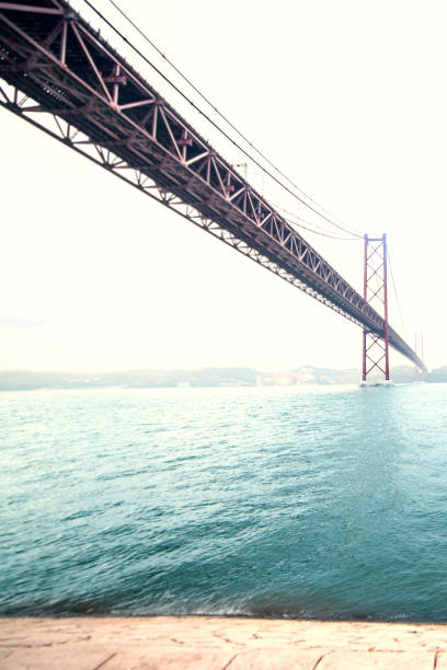 Beautiful B ridge over  river  with wide angle view. The 25 de Abril bridge over Tagus river and Christ monument in Lisbon, Portugal