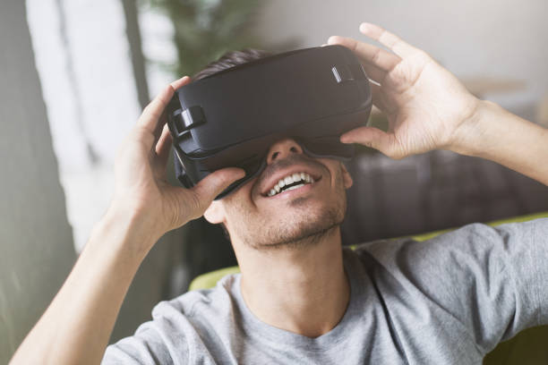 istock Close up portait of man, experiencing virtual reality while using VR set headset for entertaining, sitting in coworking studio. Headshot of handsome guy enjoying new reality, wearing VR goggles 675823822