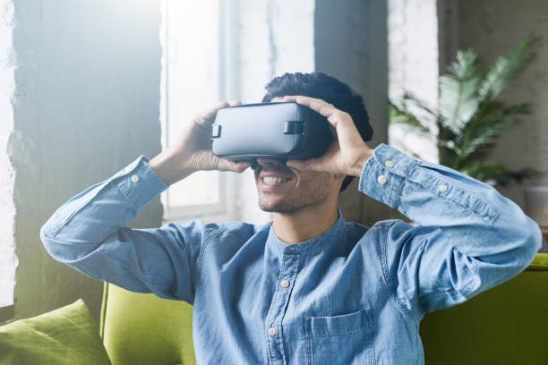 istock Smartphone using with VR headset. Astonished young caucasian male holding VR set headset on hands, experiencing virtual reality while playing video game or waching movie. Lens flares effect 675823826