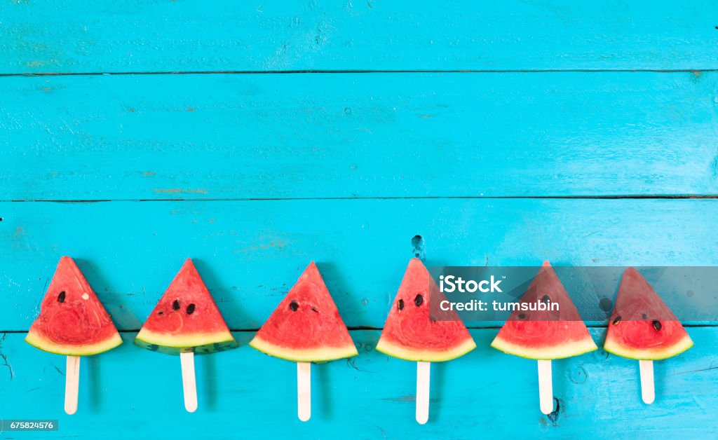 the summer watermelon slice popsicles on a blue rustic wood background. copy space for designer summer watermelon slice popsicles on a blue rustic wood background. copy space for designer Watermelon Stock Photo