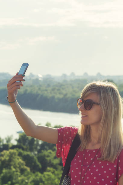 istock Girl using cellphone with city scape in the background. 675824680
