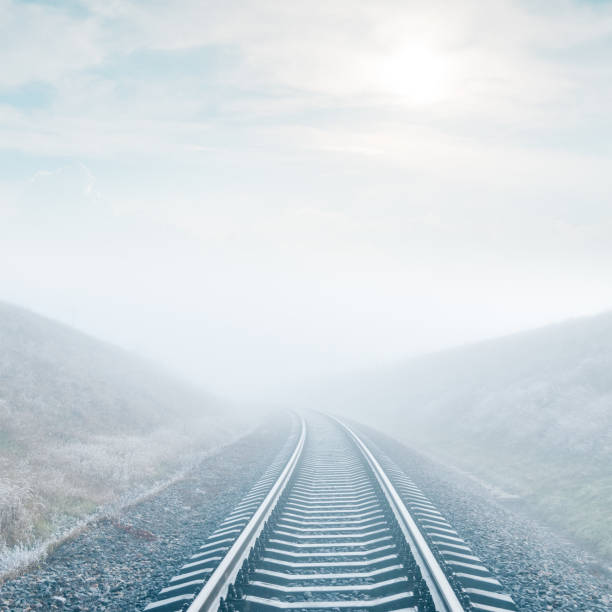 railroad in fog and sun in clouds