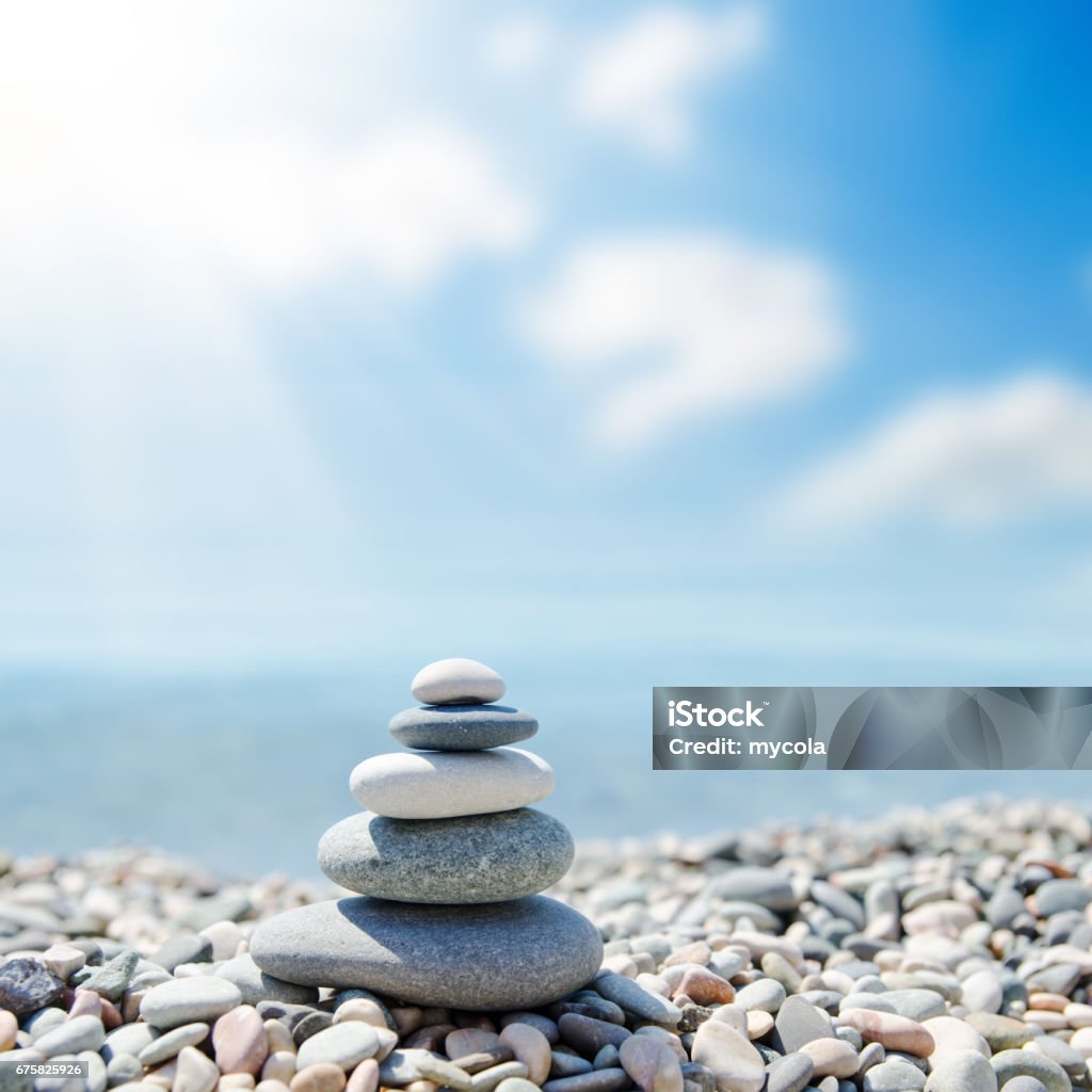 zen-like stones on beach under sun zen-like stones on beach under sun. soft focus Balance Stock Photo