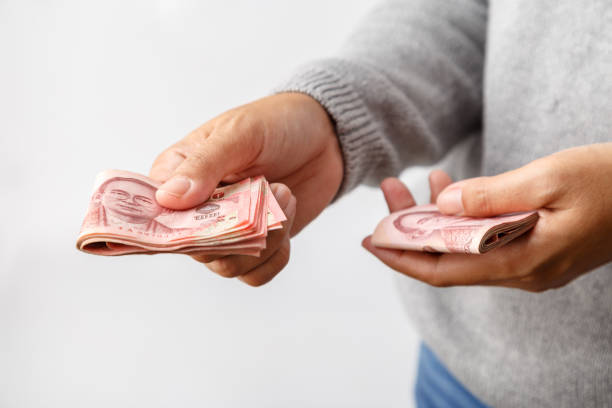 istock Female hands giving thai money. 675827452