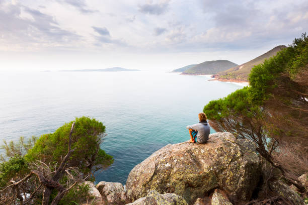 Panoramic Ocean View A man sits overlooking a panoramic view of a beautiful coastline near Newcastle, Australia. newcastle new south wales photos stock pictures, royalty-free photos & images