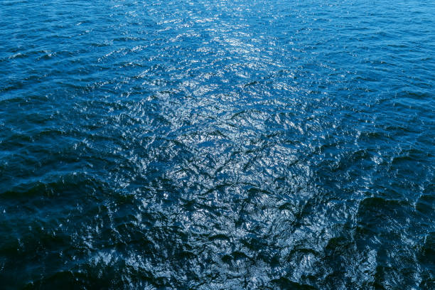istock aerial view to blue water with sun reflections 675828486