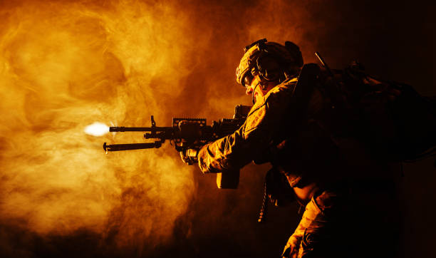 Army Ranger in field Uniforms Security forces operator in Combat Uniforms with machine gun, shooting in the face of danger. Facing enemy, he is ready to protect the nation. Gun blazing. Studio contour silhouette shot, backlight, profile side view machine gun stock pictures, royalty-free photos & images