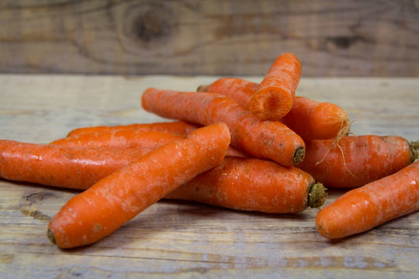 istock Bunch organic carrots on a wooden background 675897170