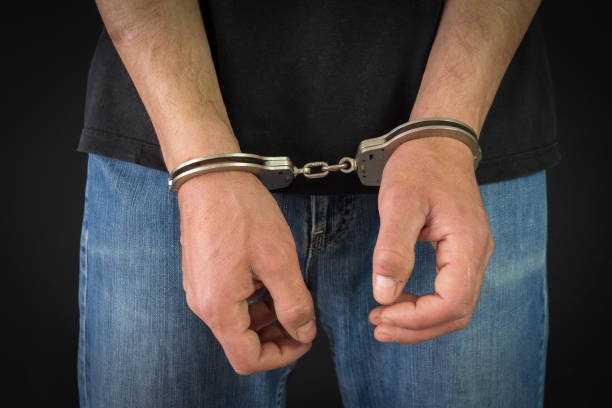 istock Criminal in handcuffs arrested for crimes in his home 675897380