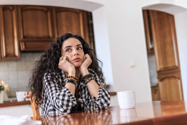 istock Young woman sitting alone at home 675903458