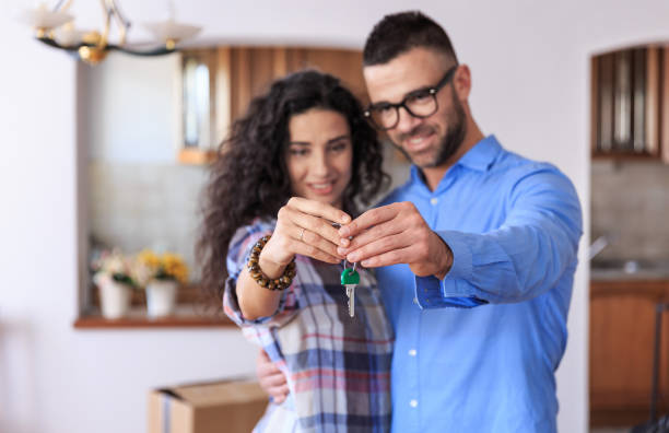 istock Couple cheerful home owners holding a key 675903462