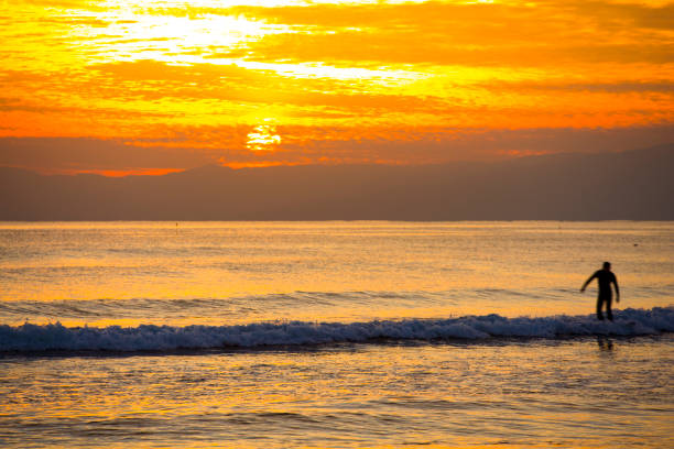 istock Beautiful sunset on the beach with surfer 675916624
