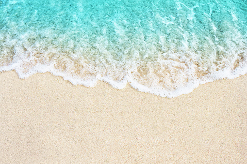 Soft blue ocean wave on sandy beach. Background.