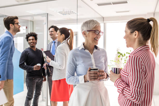istock Group of happy business people communicating on a break in a hallway. 675930192