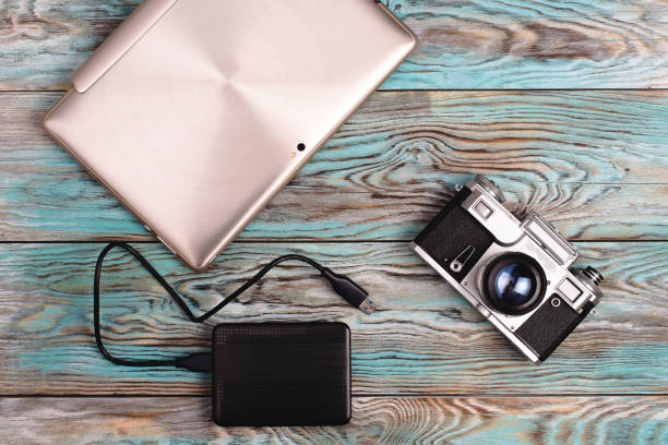istock The tablet and camera lying on wooden blue background 675930332