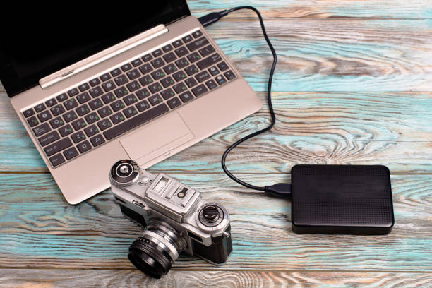istock The tablet and camera lying on wooden blue background 675930788