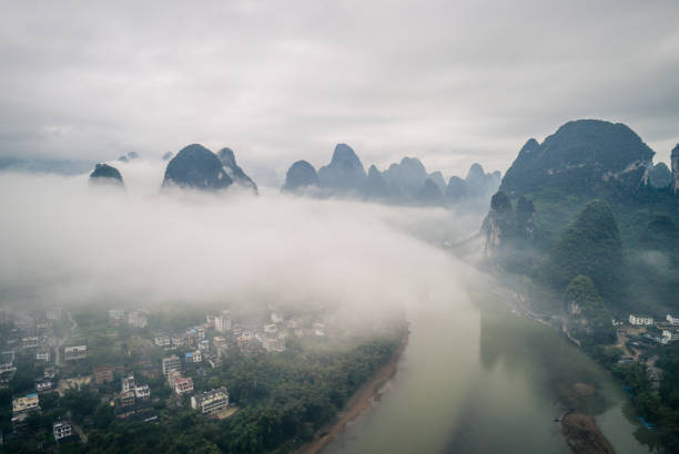 vue aérienne du paysage nuageux au-dessus des terres agricoles et des montagnes - yangshuo photos et images de collection