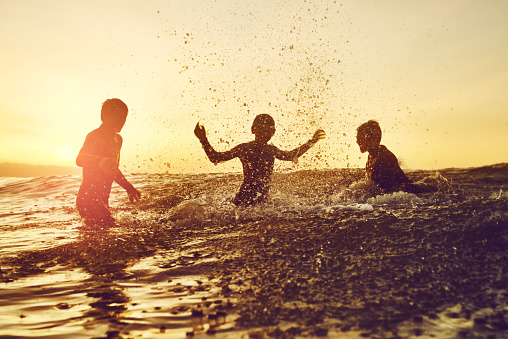 Shot of three young boys having fun in the water
