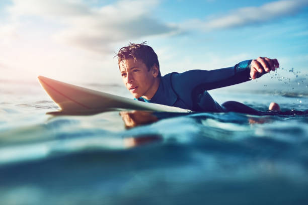 Surfing inspires independence Shot of a young boy out surfing using a paddle stock pictures, royalty-free photos & images