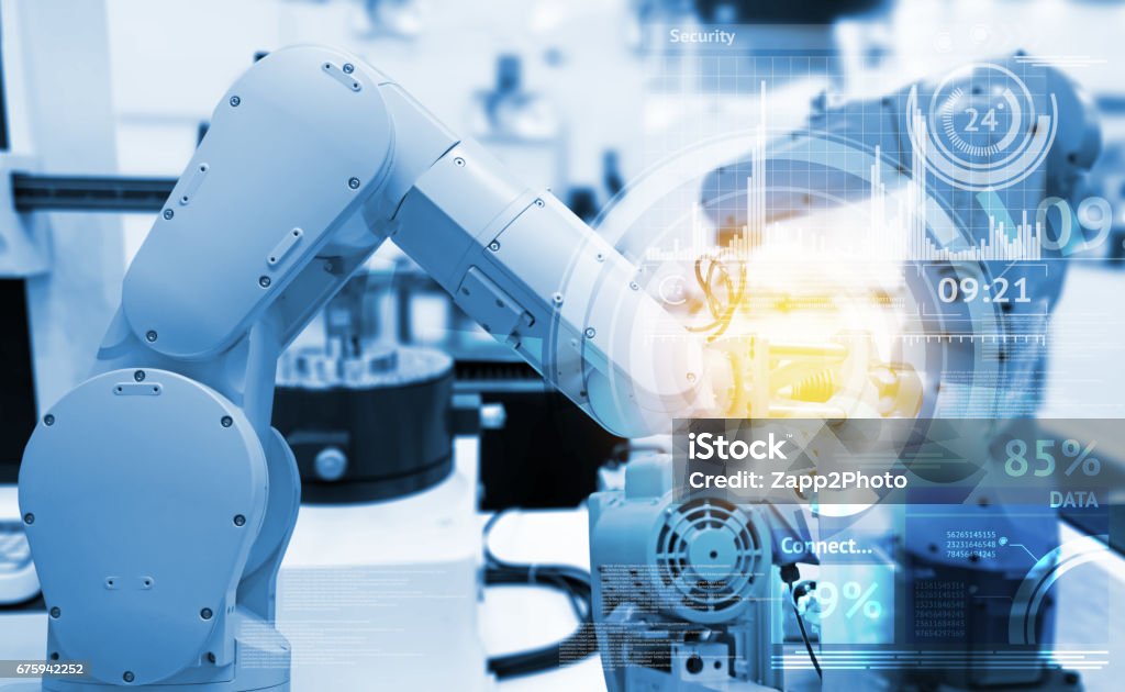 Industrial internet of things and industry 4.0 concept. Abstract blue background of technology graphic and automation wireless control robotic machine in smart factory with flare light effect. Computer-Aided Manufacturing Stock Photo