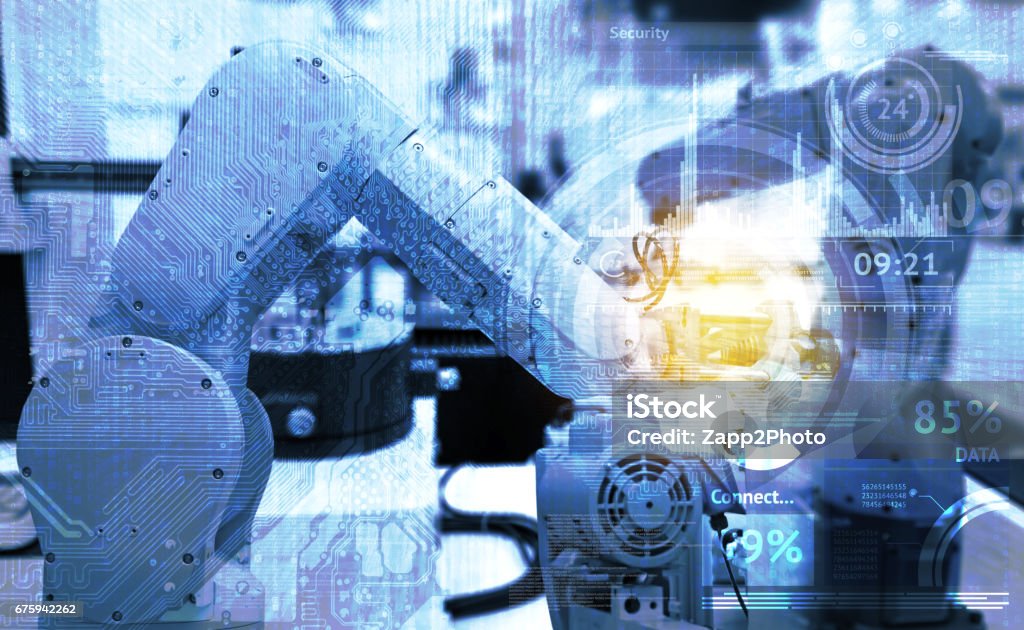Industrial internet of things and industry 4.0 concept. Abstract blue background of technology graphic and automation wireless control robotic machine in smart factory with flare light effect. Industry Stock Photo