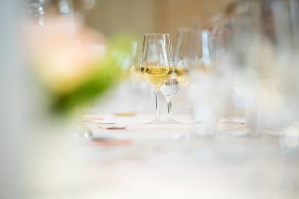 glass of white wine at table stock photo