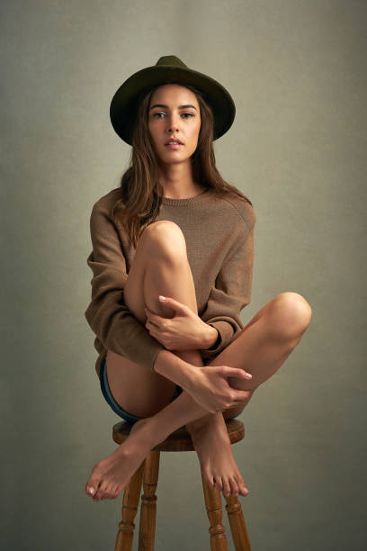 Shot of a beautiful young woman sitting against a brown background