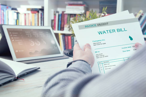 Man holds invoice of water usage stock photo