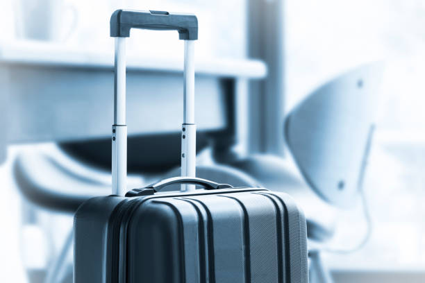 istock A modern, black wheeled suitcase beside a table and chairs 675959178
