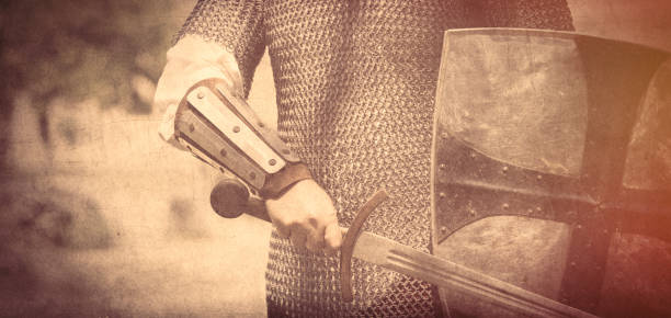 istock strong knight hand with beautiful sword and shield on the middle ages decoration background 675964868