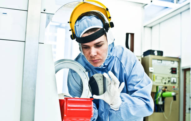 Female Scientist Working on Silicon Wafer Fabrication in Cleanroom stock photo