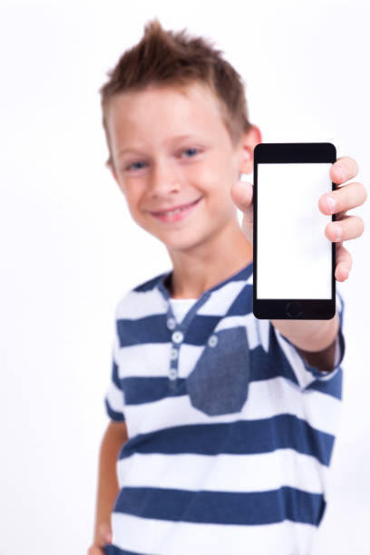 istock Successful student with a phone in his hand on a white background shows the application, photo with depth of field 675980038