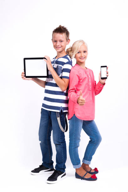 istock smiling schoolchildren learn about the world and communicate with the help of modern tablets and phones, an interesting training 675980518