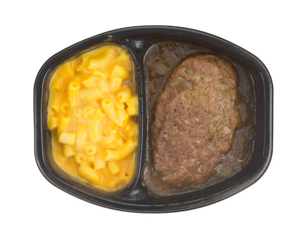 Salisbury steak meal with macaroni and cheese TV dinner Top view of a TV dinner meal of salisbury steak with gravy macaroni and cheese in a black tray isolated on a white background. salisbury steak stock pictures, royalty-free photos & images