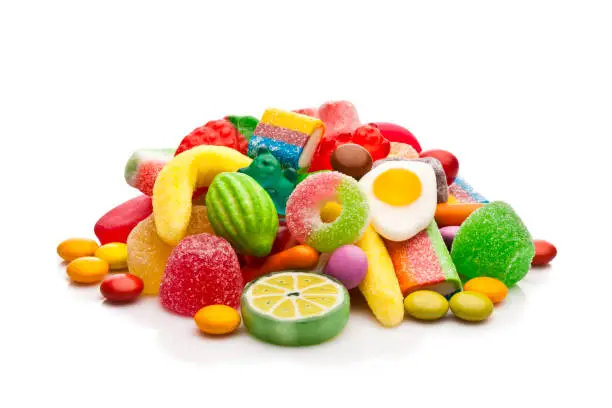 Photo of Colorful candies heap isolated on white background
