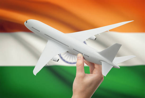 Airplane in hand with flag on background - India stock photo