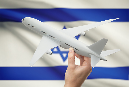 Airplane in hand with national flag on background - Israel