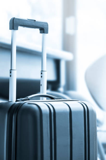 istock A modern, black wheeled suitcase beside a table and chairs 675997346