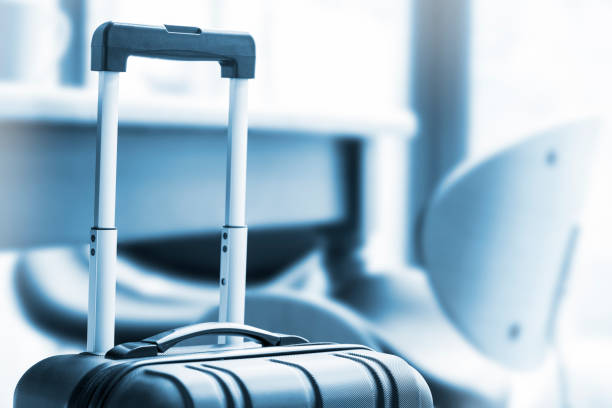 istock A modern, black wheeled suitcase beside a table and chairs 675997508