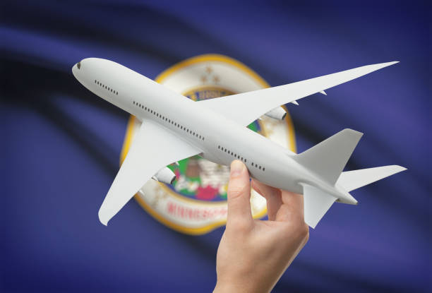 istock Airplane in hand with US state flag on background - Minnesota 675997720