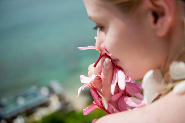 Woman smelling bouquet of tropical flowers