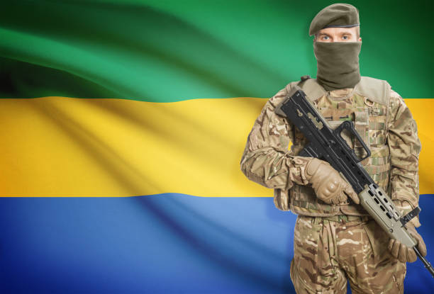 istock Soldier holding machine gun with flag on background series - Gabon 676008678