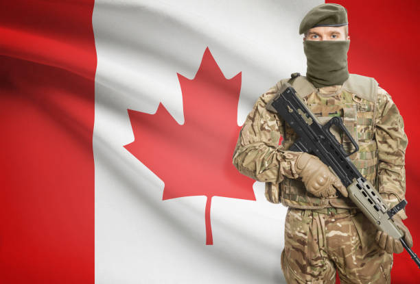 istock Soldier holding machine gun with flag on background series - Canada 676008818