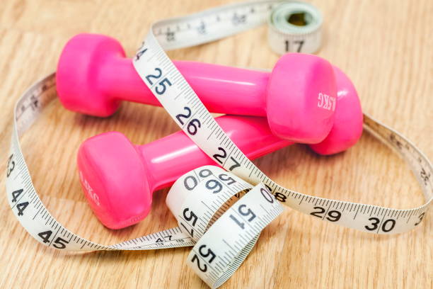 istock Dumbbells and tape measure on floor 676009138