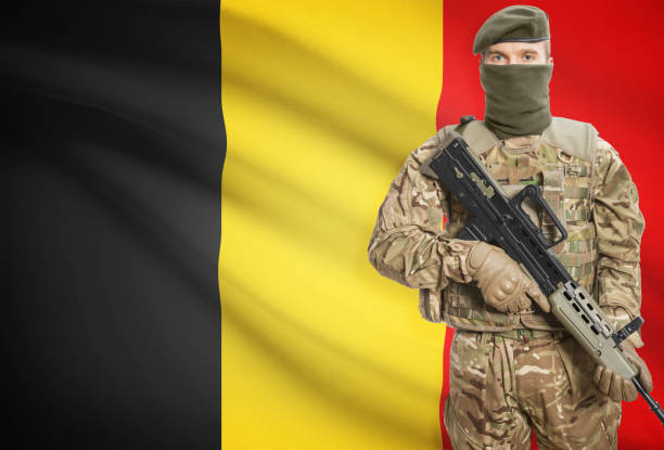 Soldier holding machine gun with national flag on background - Belgium