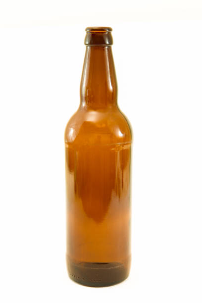 A wooden beer caddy with beer filled bottles, shot overhead on a rustic worn wooden background, lit by natural light. 