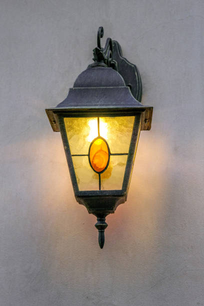 istock Old street lamp on the wall shines 676012388