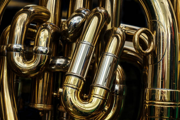 Detail of the brass pipes of a tuba Detail of the brass pipes of a tuba. Abstract background showing the curves and joints of this polished brass band musical instrument. brass instrument stock pictures, royalty-free photos & images